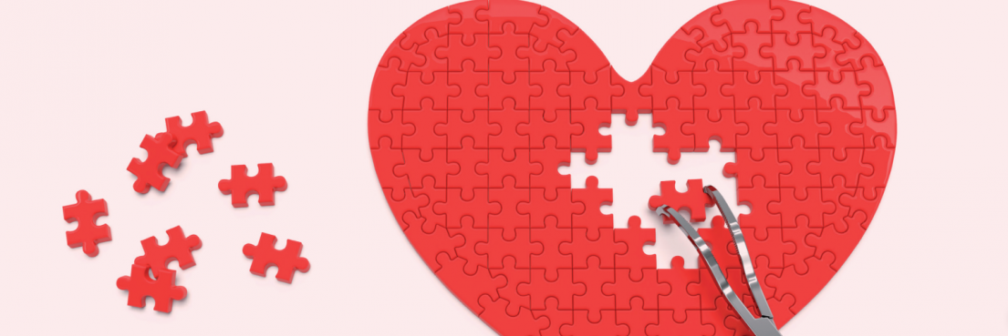 Rotes Herzpuzzle mit fehlenden Teilen, zwei Pinzetten halten Puzzleteile über der Lücke.